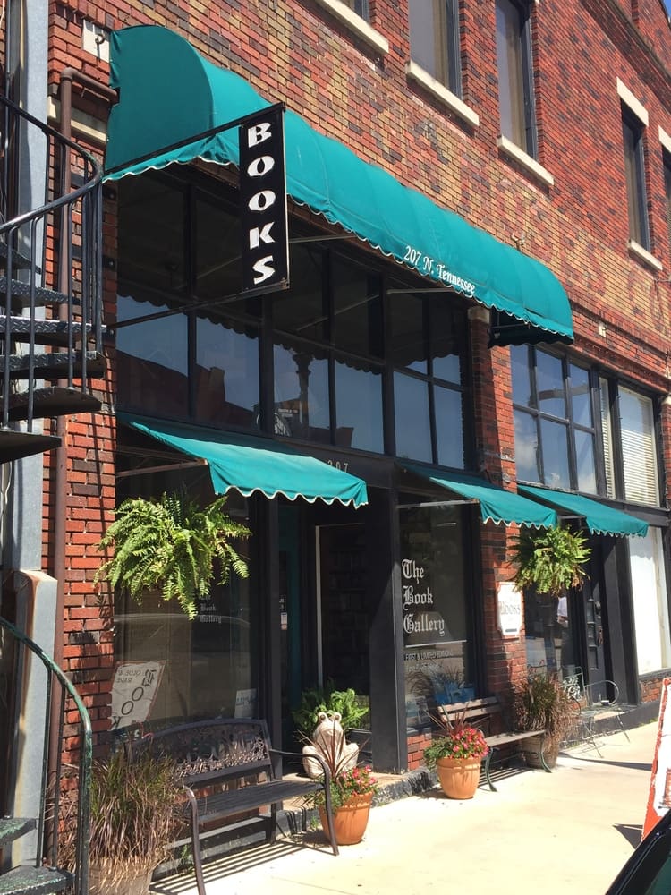 A building with green awnings on the front of it.